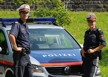 Zwei Polizisten mit Streifenwagen